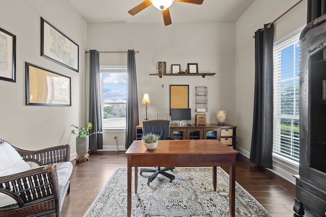 office space featuring a ceiling fan, baseboards, and wood finished floors