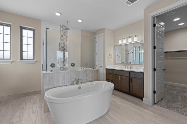 305 Miranda Way, Georgetown, TX 78633 - bathroom featuring a stall shower, a freestanding tub, vanity, a spacious closet, and recessed lighting