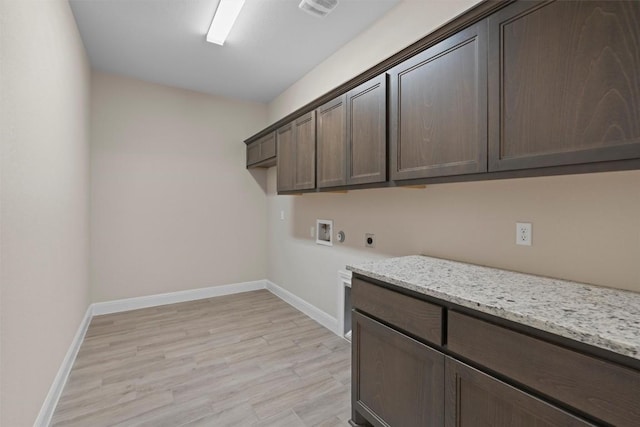 laundry room with cabinets, electric dryer hookup, hookup for a washing machine, and light hardwood / wood-style floors