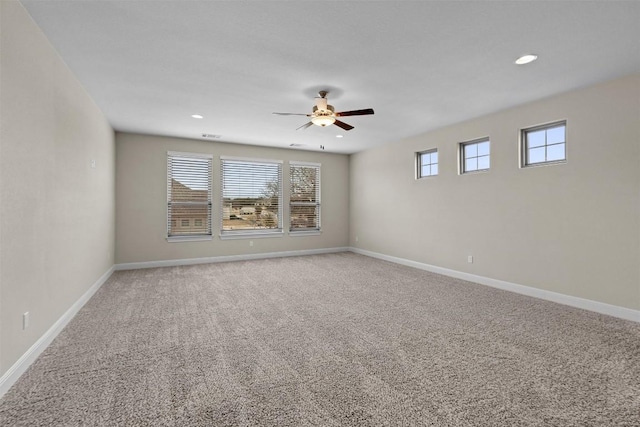 spare room with ceiling fan and carpet