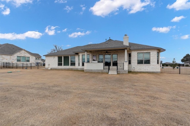 back of property featuring a yard and ceiling fan