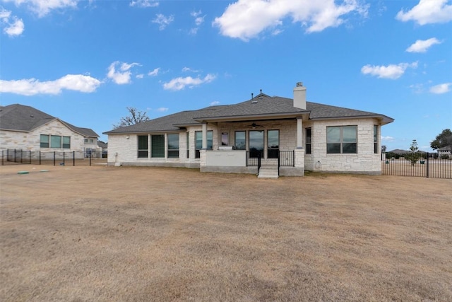 305 Miranda Way, Georgetown, TX 78633 - back of property with stone siding, a ceiling fan, a chimney, a fenced backyard, and a porch
