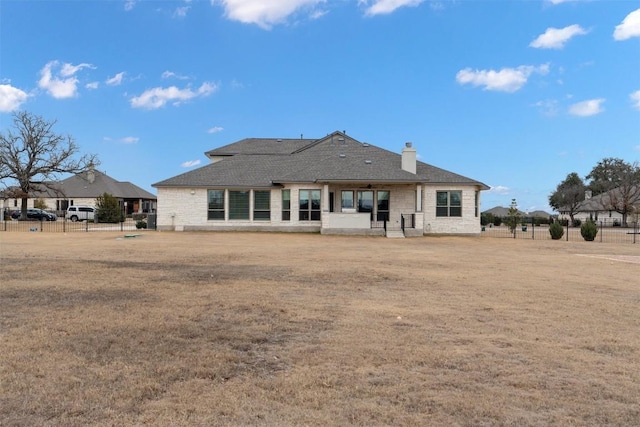 rear view of property featuring a yard