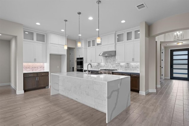 305 Miranda Way, Georgetown, TX 78633 - kitchen with double oven, decorative backsplash, a spacious island, white cabinets, and recessed lighting