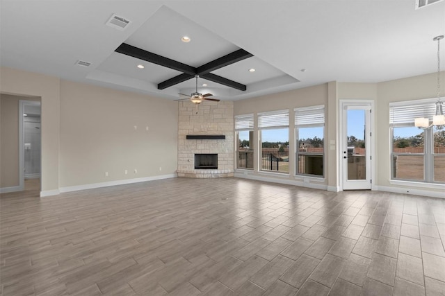 unfurnished living room with coffered ceiling, ceiling fan with notable chandelier, a fireplace, and light wood-type flooring