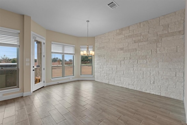 unfurnished dining area with an inviting chandelier