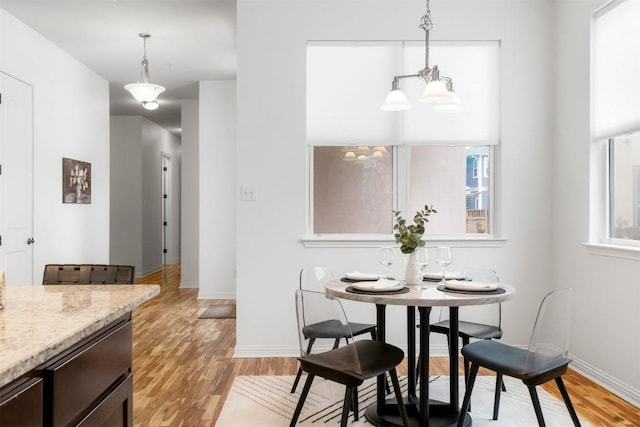 dining room featuring a notable chandelier and light wood-type flooring