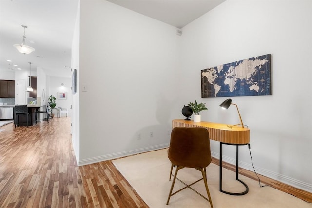 home office with light hardwood / wood-style flooring