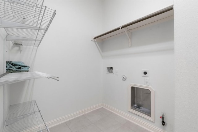 washroom featuring gas dryer hookup, washer hookup, light tile patterned floors, and electric dryer hookup