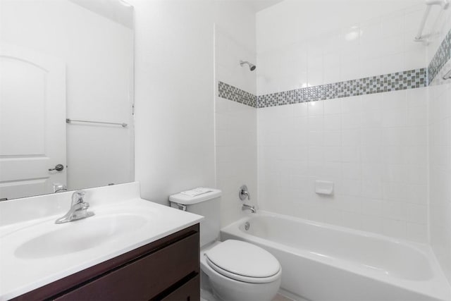 full bathroom featuring vanity, tiled shower / bath combo, and toilet