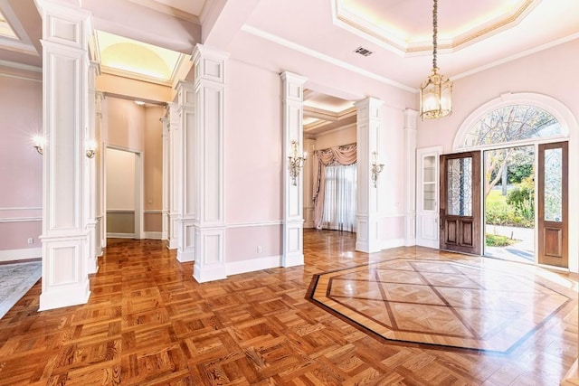 entrance foyer featuring an inviting chandelier, crown molding, parquet flooring, and ornate columns