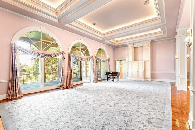 spare room featuring ornamental molding, a raised ceiling, and decorative columns