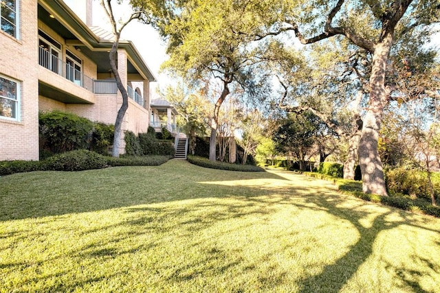 view of grassy yard with stairs