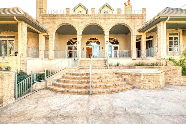 property entrance with brick siding and ceiling fan