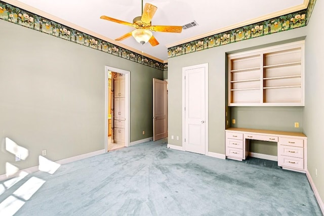 unfurnished bedroom with carpet floors, ensuite bath, an office area, and ceiling fan