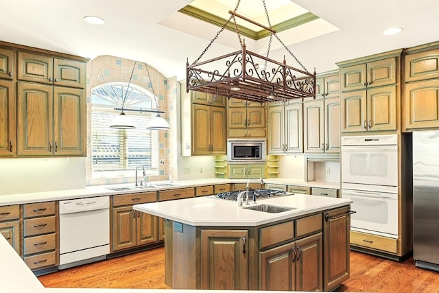 kitchen featuring appliances with stainless steel finishes, light countertops, light wood-style floors, a center island with sink, and recessed lighting