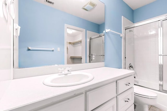 full bathroom featuring toilet, bath / shower combo with glass door, vanity, and visible vents