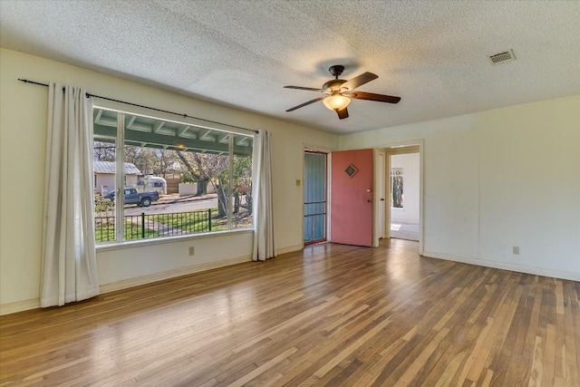 empty room featuring hardwood / wood-style flooring, ceiling fan, and a textured ceiling