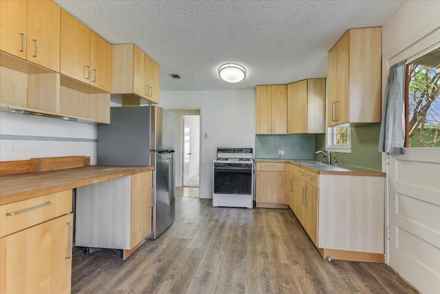 kitchen featuring stainless steel refrigerator, light brown cabinetry, wood-type flooring, sink, and white range oven