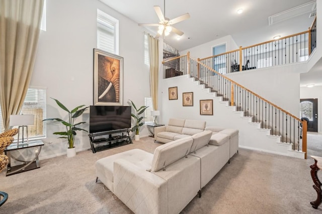 carpeted living room with a towering ceiling and ceiling fan