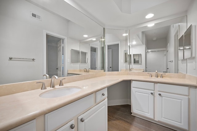 bathroom featuring walk in shower, vanity, and hardwood / wood-style floors