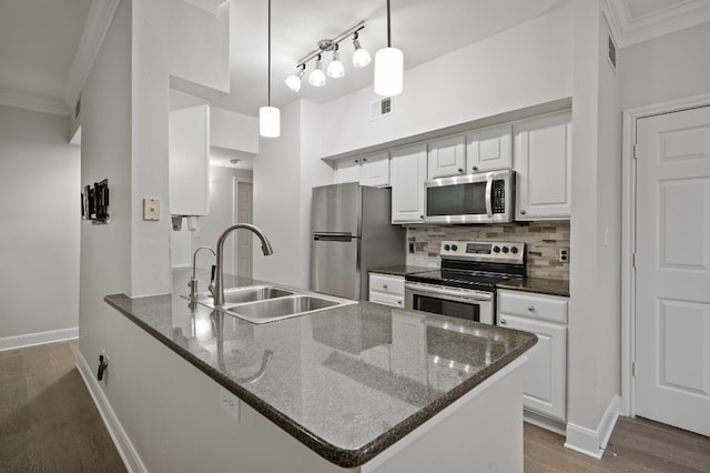 kitchen with white cabinetry, stainless steel appliances, kitchen peninsula, and sink