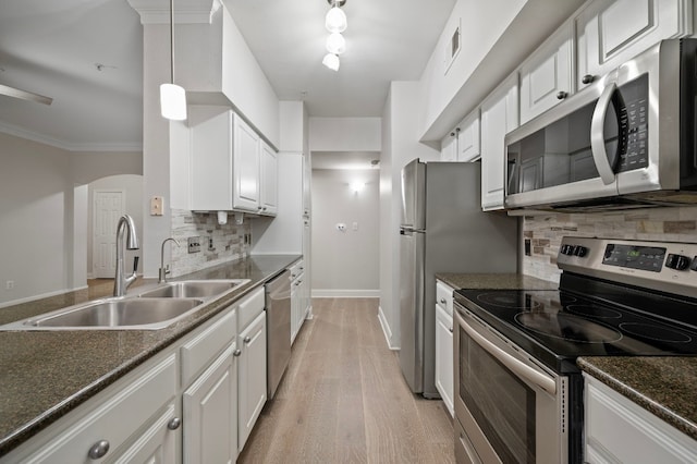 kitchen with sink, hanging light fixtures, stainless steel appliances, light hardwood / wood-style floors, and white cabinets