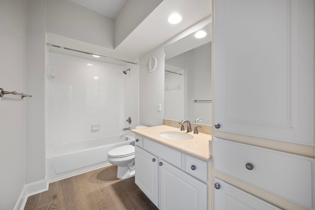 full bathroom with wood-type flooring, toilet, tiled shower / bath combo, and vanity