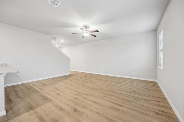 empty room with ceiling fan and light hardwood / wood-style floors