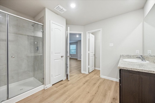 bathroom featuring vanity, a shower with door, and hardwood / wood-style floors