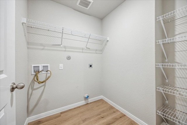 washroom featuring gas dryer hookup, electric dryer hookup, wood-type flooring, and washer hookup