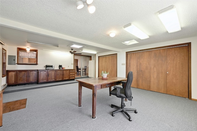 office space featuring light carpet, electric panel, and a textured ceiling