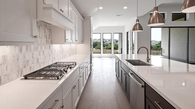 312 Leaning Rock Rdg, Austin, TX 78737 - kitchen featuring appliances with stainless steel finishes, light countertops, wood finished floors, white cabinets, and decorative backsplash