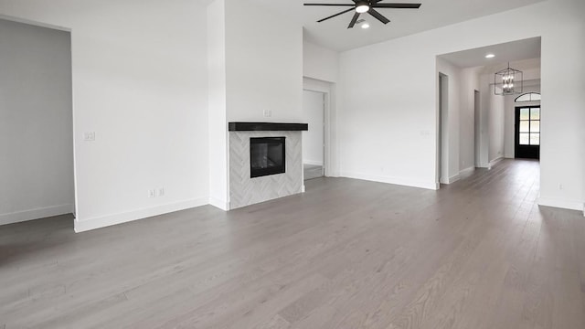312 Leaning Rock Rdg, Austin, TX 78737 - unfurnished living room with ceiling fan, a premium fireplace, a chandelier, wood finished floors, and recessed lighting