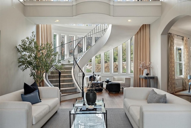 living room with hardwood / wood-style flooring, a towering ceiling, and radiator heating unit