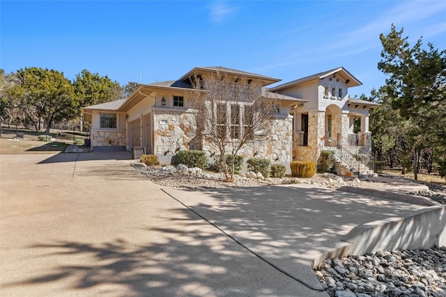 804 Laughing Dog Ct, Leander, TX 78641 - view of front facade featuring stone siding, concrete driveway, an attached garage, and stucco siding