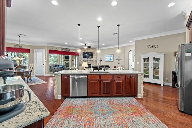 804 Laughing Dog Ct, Leander, TX 78641 - kitchen with stainless steel appliances, open floor plan, healthy amount of natural light, a sink, and ornamental molding