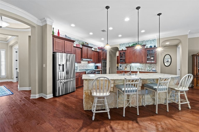 804 Laughing Dog Ct, Leander, TX 78641 - kitchen featuring appliances with stainless steel finishes, ornamental molding, arched walkways, backsplash, and glass insert cabinets