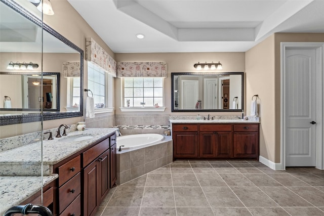 804 Laughing Dog Ct, Leander, TX 78641 - bathroom featuring two vanities, a bath, and tile patterned floors