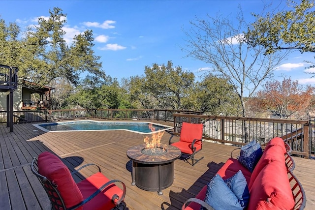 wooden terrace featuring a fenced in pool and an outdoor living space with a fire pit