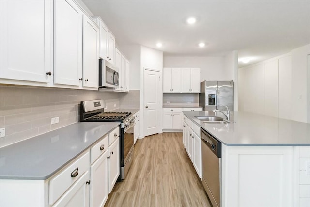 kitchen featuring white cabinetry, appliances with stainless steel finishes, sink, and an island with sink