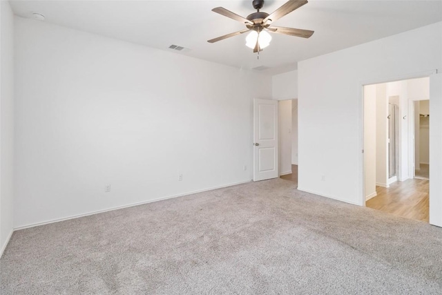 spare room with ceiling fan and light carpet