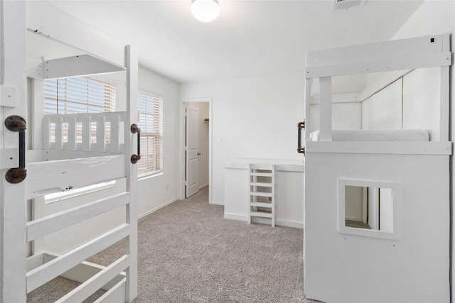 walk in closet featuring light colored carpet