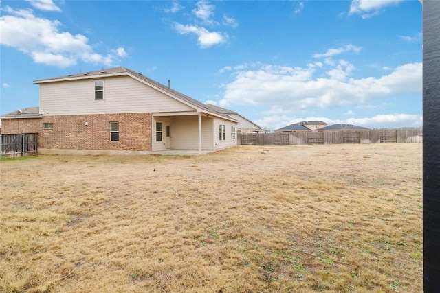 rear view of property with a patio and a lawn