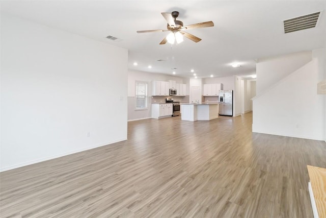 unfurnished living room with ceiling fan and light hardwood / wood-style floors