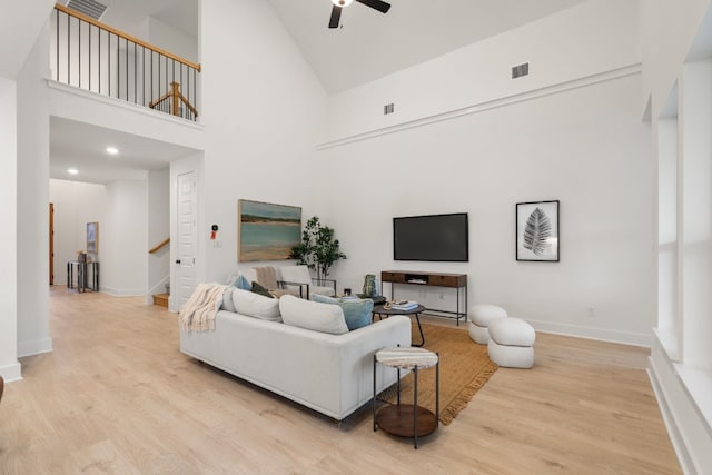 living room featuring ceiling fan, high vaulted ceiling, and light wood-type flooring