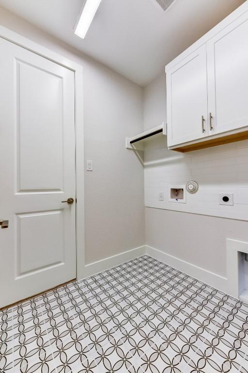 clothes washing area featuring cabinets, gas dryer hookup, and electric dryer hookup