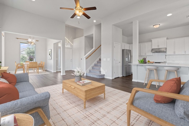 living room with hardwood / wood-style flooring and ceiling fan with notable chandelier