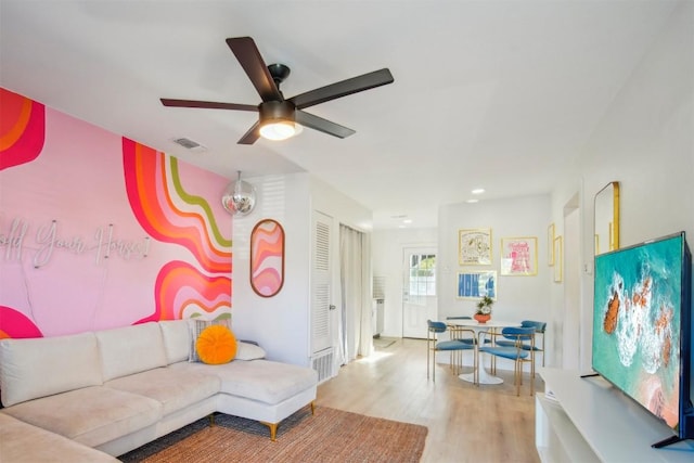 living room featuring ceiling fan and light hardwood / wood-style floors