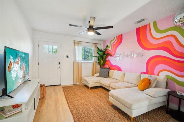 living room with light hardwood / wood-style flooring and ceiling fan